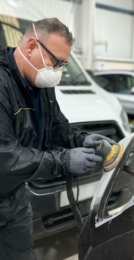 Bodyshop technician preparing a van panel for respray