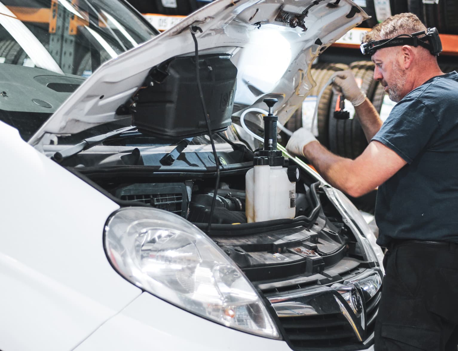 Technician working under the bonnet of a van in the Dack workshop